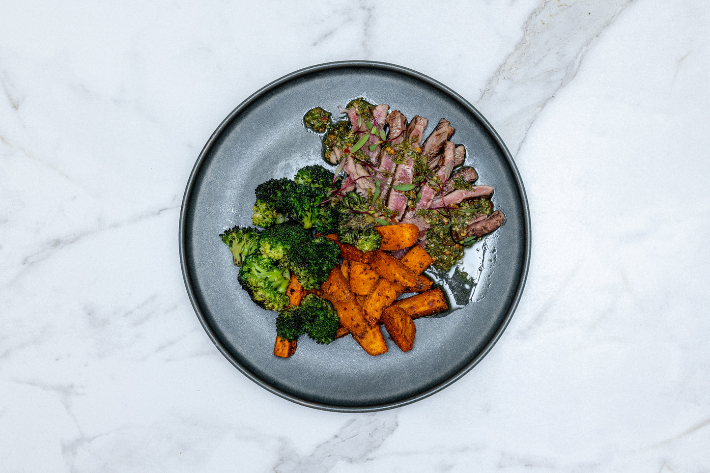 Sirloin al Chimichurri con Gajos de Papas de Camote al Ajo Picante y Brócoli a la Parrilla